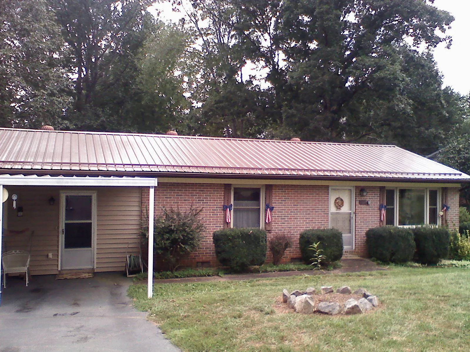Bronze metal roof and carport on a brick ranch home — Roof Repair work by our crew in Bridger